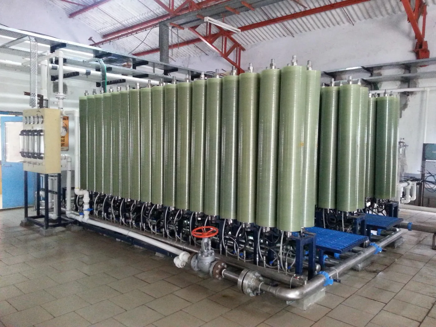 Row of green RCDT membrane modules on a skid with stainless steel pipework
