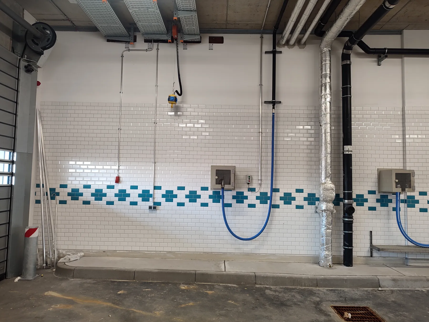 Schlauchstation für Trinkwasser in einer gefliesten Halle an einem Flughafen